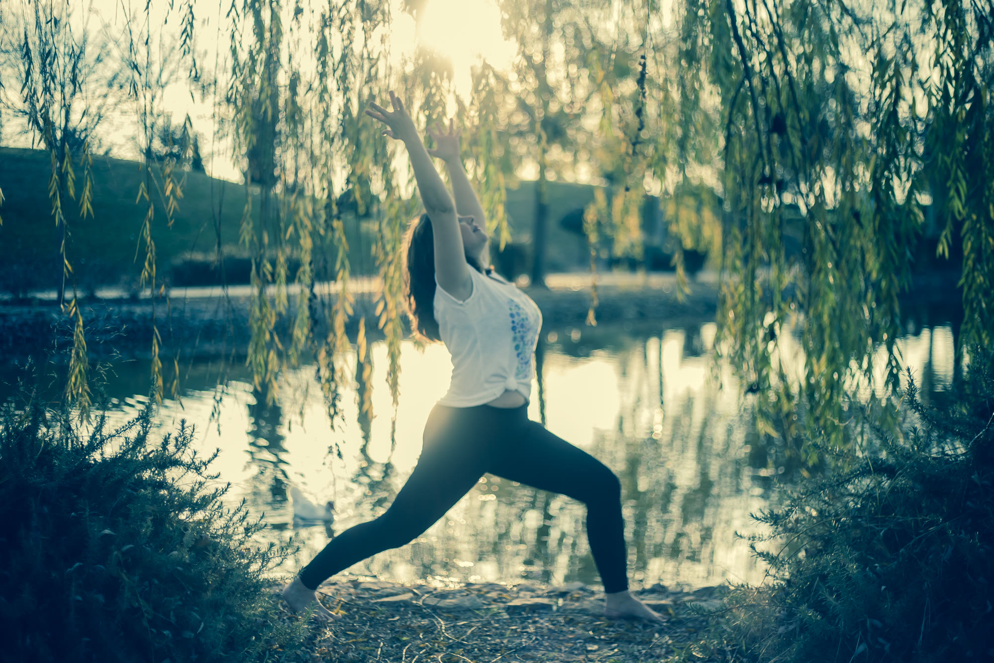 Rocío practicando yoga junto a un lago al atardecer